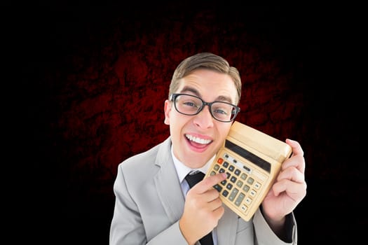 Geeky smiling businessman showing calculator against brown