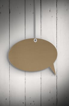 Speech bubble tag hanging against white wood