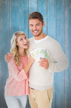 Attractive couple flashing their cash against wooden planks