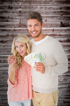 Attractive couple flashing their cash against wooden planks