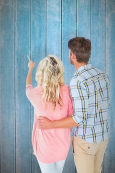 Attractive couple standing and looking against wooden planks