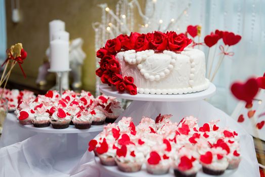 Beautiful wedding cake and cupcakes in decoration