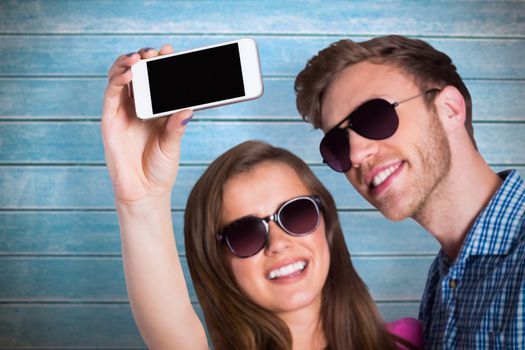Couple taking selfie with smart phone against wooden planks