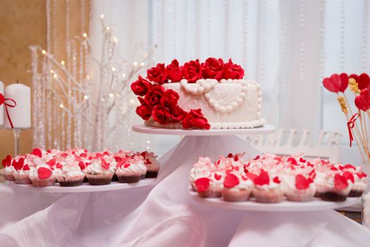 Beautiful wedding cake and cupcakes in decoration