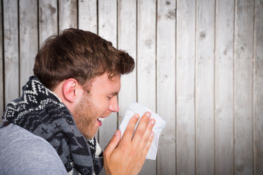 Close up side view of man blowing nose against wooden planks