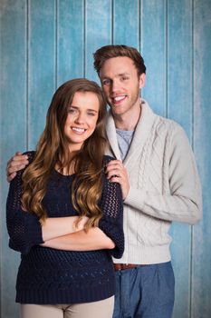 Portrait of smiling young couple against wooden planks