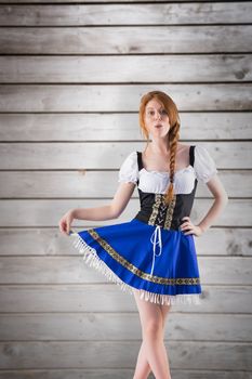 Oktoberfest girl spreading her skirt against wooden planks