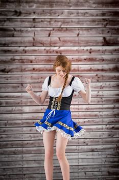 Oktoberfest girl moving and dancing against wooden planks