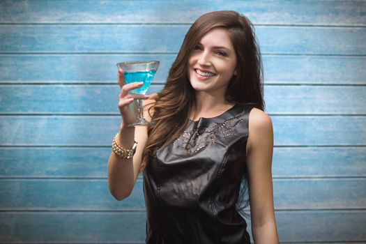 Brunette with cocktail against wooden planks
