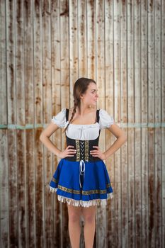Pretty oktoberfest girl with hands on hips against wooden planks