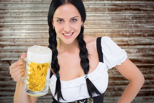 Pretty oktoberfest girl holding beer tankard against wooden planks