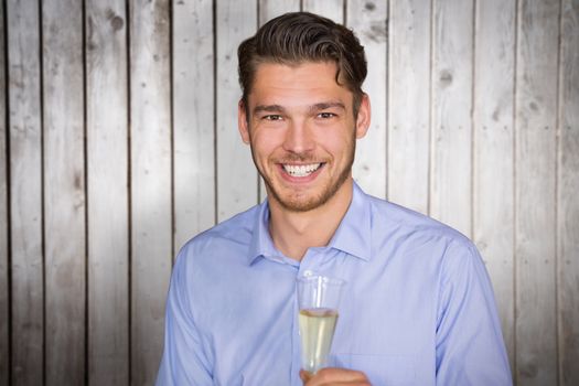Man toasting with champagne against wooden planks