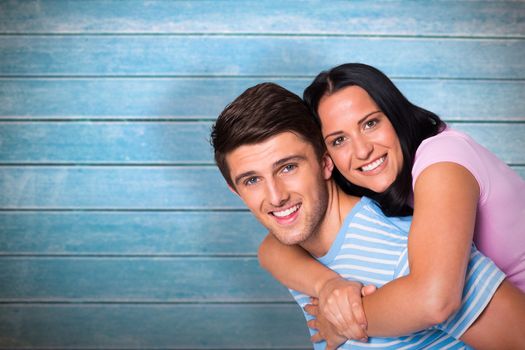 Young couple smiling at the camera against wooden planks