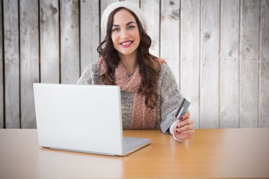 Woman with credit card against wooden planks