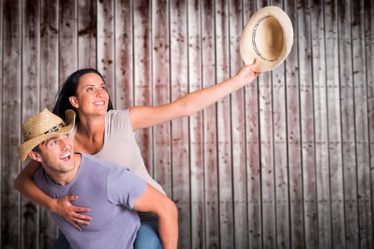 Man giving his pretty girlfriend a piggy back against wooden planks