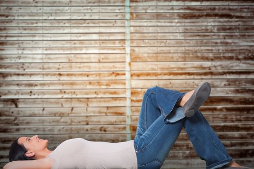 Young woman lying on floor thinking against wooden planks