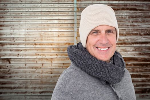 Casual man in warm clothing against wooden planks