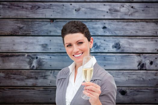 Businesswoman toasting with champagne against grey wooden planks