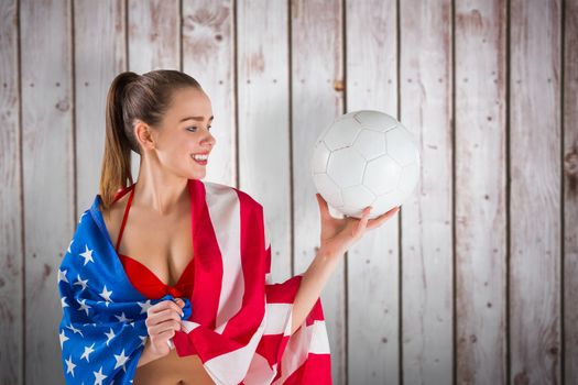 Pretty girl in bikini with american flag against wooden planks