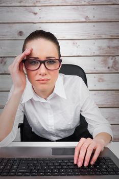 Businesswoman typing on a keyboard against wooden planks