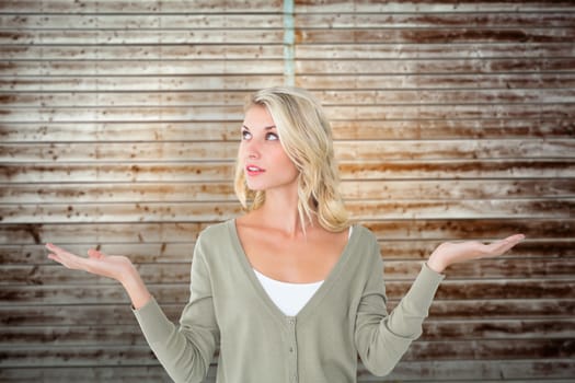 Pretty young blonde holding hands out against wooden planks