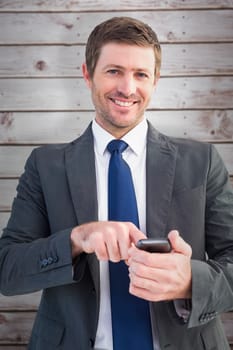 Businessman sending a text message against wooden planks