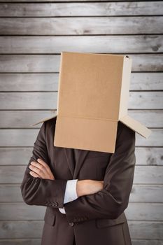 Anonymous businessman with arms crossed against wooden planks