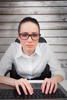 Businesswoman typing on a keyboard against wooden planks