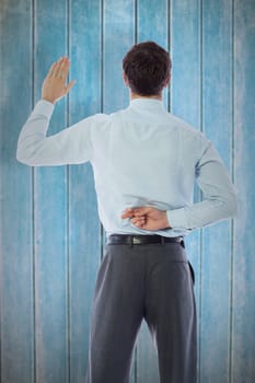 Businessman crossing fingers behind his back against wooden planks