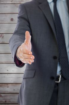 Businessman reaching hand out against wooden planks