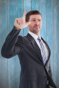Serious businessman standing and pointing against wooden planks