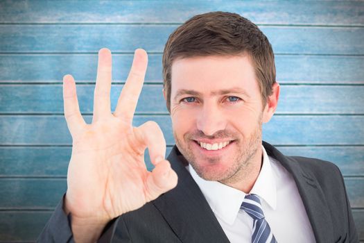 Businessman smiling and making ok sign against wooden planks