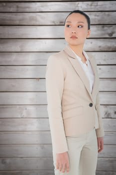 Unsmiling asian businesswoman against wooden planks