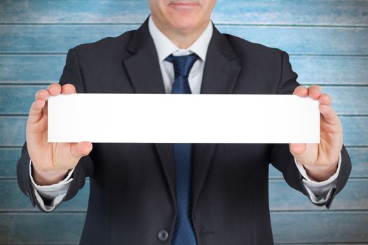 Mature businessman showing card against wooden planks