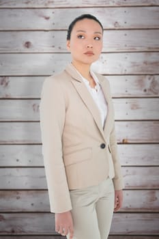 Unsmiling asian businesswoman against wooden planks