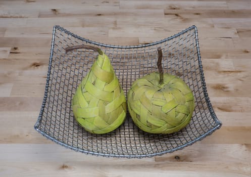 Green pear and apple made from bast fibre, in the silver basket