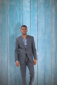 Businessman standing looking at camera against wooden planks