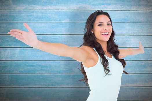 Carefree brunette with arms out against wooden planks