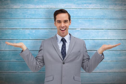 Smiling businessman presenting something with his hands against wooden planks