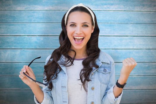 Cheering brunette against wooden planks