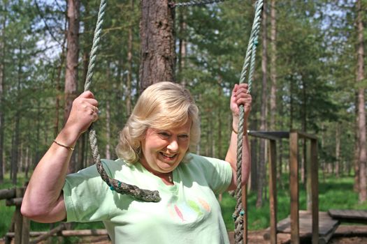 Active senior female holding ropes on a course