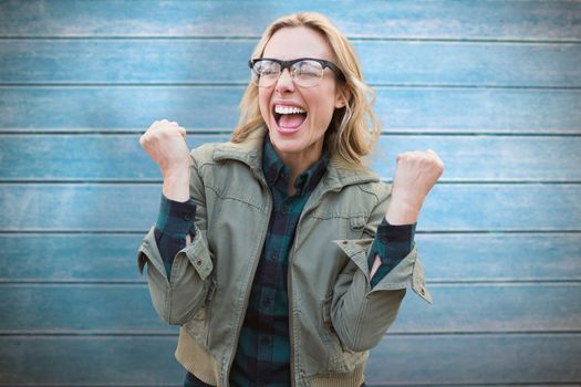 Pretty blonde cheering against wooden planks