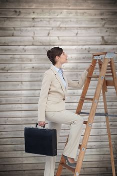 Businesswoman climbing career ladder with briefcase against wooden planks background