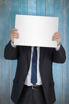 Mature businessman showing card against wooden planks