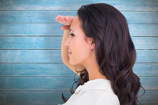 Pretty brunette looking with hand up against wooden planks