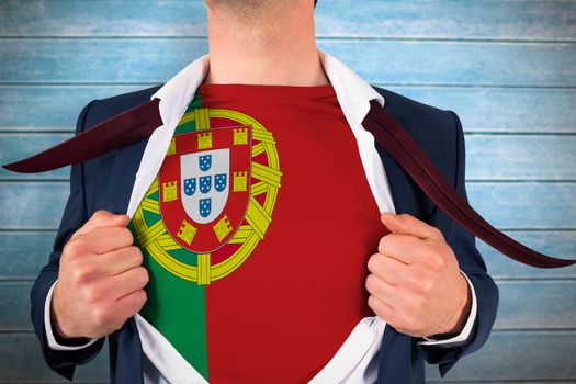 Businessman opening shirt to reveal portugal flag against wooden planks