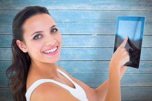 Pretty brunette using tablet pc against wooden planks