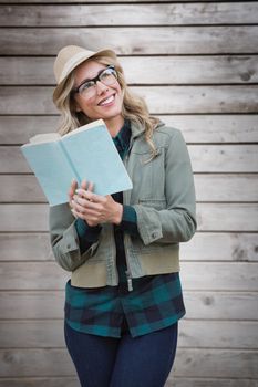 Pretty hipster reading against wooden planks