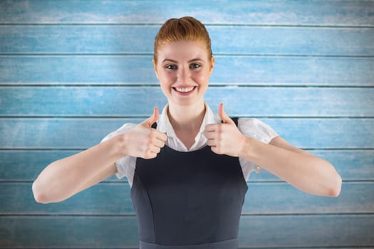 Redhead businesswoman showing thumbs up against wooden planks