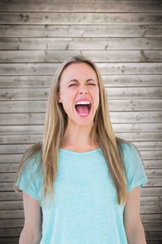 Furious blonde standing and screaming against wooden planks background